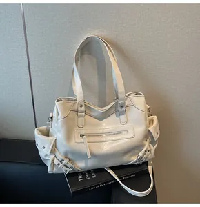 Detail of cream white faux leather tote bag with silver hardware and utility pockets