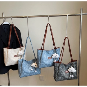 Detail of four vintage floral tote bags with woven straps and cloud plush charms