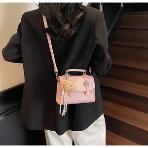 Détail du sac bandoulière rose en similicuir avec étoile en métal et breloque ours