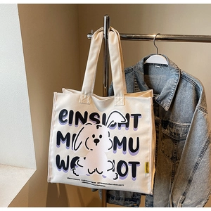 Detail of white canvas tote bag with bunny print and lettering on a clothes hanger