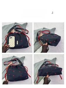 Detail view of denim bucket bag with cherry embroidery and drawstring closure
