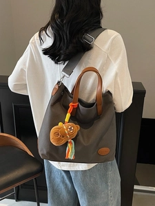 Chic dark gray canvas tote bag with brown leather handles and bear charm accessory