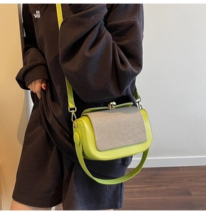 Detail of neon green pillow bag with gray woven texture and golden vintage clasp