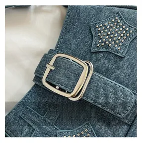 Close-up of blue denim bag with star patchwork, metal studs and silver buckle detail