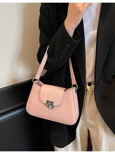Pink underarm bag with vintage pleated texture and silver twist lock on shoulder model