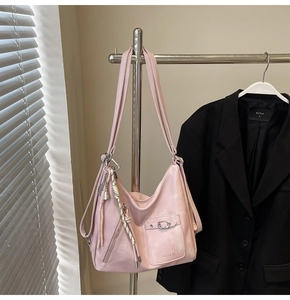 Detail of pink washed leather tote bag with silver buckle pocket and woven strap