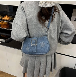 Detail of blue denim hobo bag with sparkling star rhinestones and metal buckle
