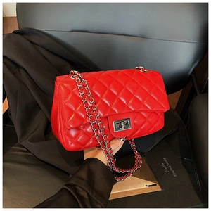 Detailed view of red quilted leather handbag with silver chain and twist-lock clasp