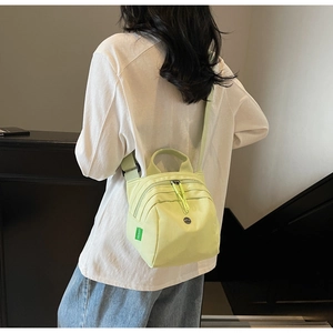 Detail of light green waterproof canvas bag with sturdy handles and adjustable strap