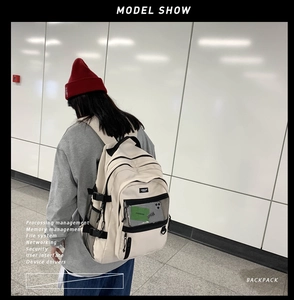 Vue détaillée du grand sac à dos d'étudiant beige avec poches filet sur mur minimaliste