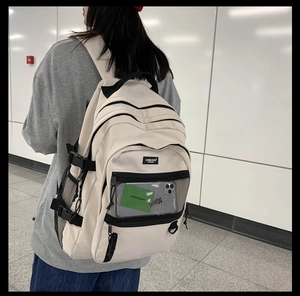 Vue arrière d'un sac à dos beige de grande capacité porté par un mannequin en intérieur