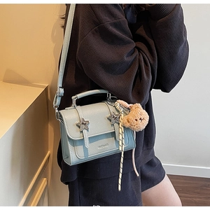 Détail du sac bandoulière en cuir bleu menthe avec étoiles argentées et ours en peluche