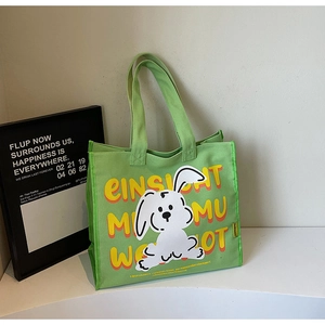 Detail of light green canvas tote bag with cartoon rabbit and artistic typography print