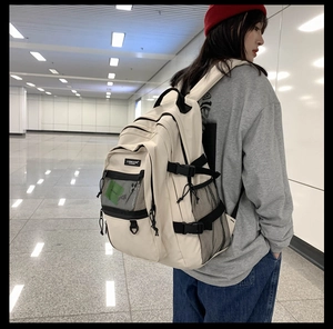 Sac à dos beige moderne avec sangles noires et poches filet dans un décor de voyage chic