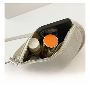 Top view of the interior capacity of a white litchi grain leather crossbody bag