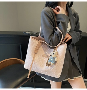 Dettaglio della borsa tote rosa con trama floreale rosa e un simpatico ciondolo a orsetto