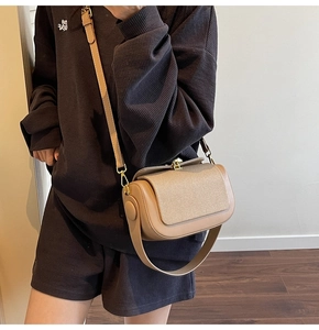 Detail of vintage khaki crossbody bag featuring woven lid texture and leather patchwork