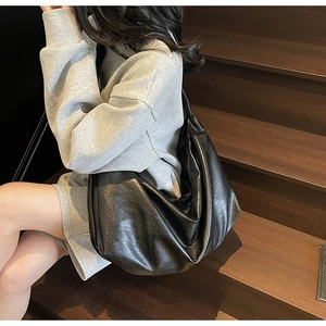 Detail view of glossy oil wax leather hobo bag with vintage texture and spacious design