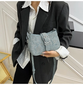 Detail of light blue denim bucket bag with sequined stars and large silver buckle