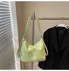 Detail of light green tote bag featuring glossy crinkled texture and metallic zipper