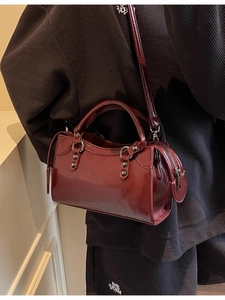 Schicke weinrote Handtasche aus Lackleder mit Nieten und verstellbarem Schultergurt