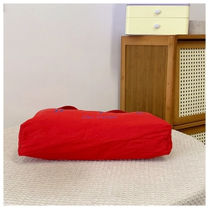 Λεπτομερής όψη της κόκκινης υφασμάτινης τσάντας με μπλε κέντημα Hope σε βαμβάκι