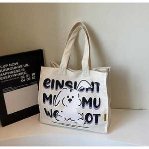 Detail shot of the durable canvas texture and cute cartoon rabbit print on a white tote bag