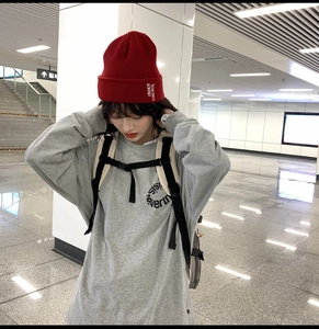 Gros plan d'un sweat gris oversize et d'un bonnet rouge pour un style urbain tendance
