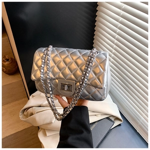Detail of silver quilted crossbody bag with metallic finish and metal twist-lock closure