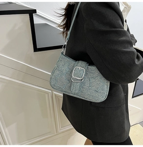 Detail of light blue denim underarm bag featuring silver rivets and Y2K star embroidery