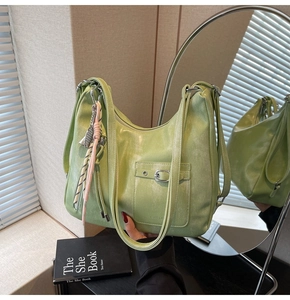 Detail of avocado green tote bag featuring utility pocket and woven knot zipper pull