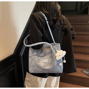 Floral print shoulder bag with braided rope handle and cloud charm in a lifestyle setting