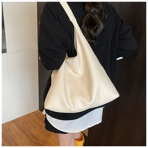 Detail of off-white oversized leather tote bag with lychee grain and wide shoulder strap