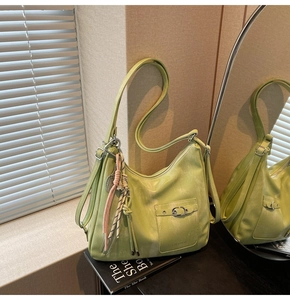 Detail of light green hobo bag featuring soft pebble texture and decorative silk scarf