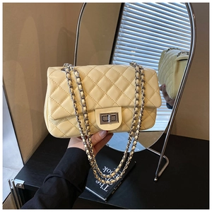 Close-up of beige quilted chain bag with silver rectangular twist lock and luxury texture