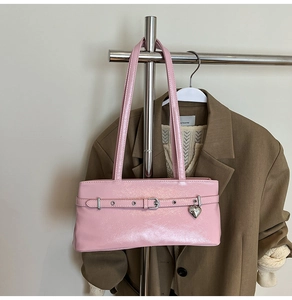 Pink patent leather underarm bag featuring a metallic silver heart charm and buckle