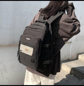 Vue latérale du grand sac à dos noir avec poches en filet et boucles réglables