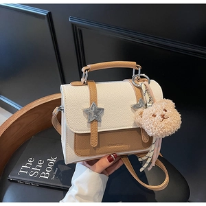 Détail du sac à main bicolore en cuir grainé avec clous étoiles argentés élégants