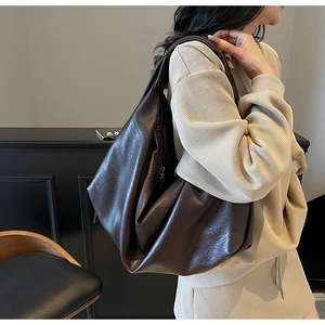 Detail showing the large capacity and vintage wrinkled texture of the dark brown shoulder bag