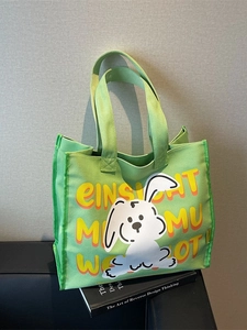 Green canvas tote bag featuring a cute white cartoon rabbit and yellow typography print