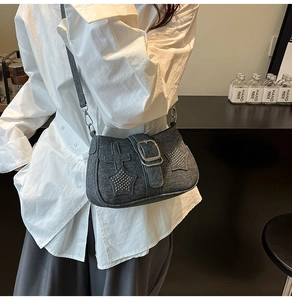 Close-up of grey denim crossbody bag featuring Y2K star patches and silver rivets details