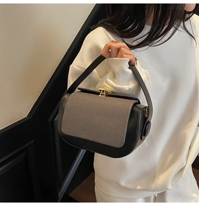 Close-up of contrast patchwork texture and gold metal buckle on the pillow handbag