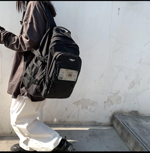 Vue latérale d'un grand sac à dos noir de style urbain porté dans un environnement extérieur