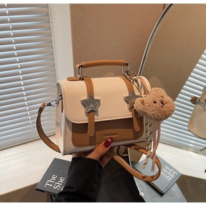 Détail du petit sac carré chic avec boucles en étoile et pendentif ours en peluche