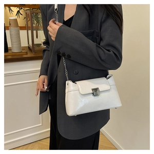 Sac à bandoulière en cuir verni blanc avec chaîne argentée et fermoir en métal élégant