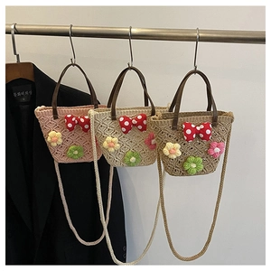 Detailed view of woven straw bucket bags with floral crochet and leather handles