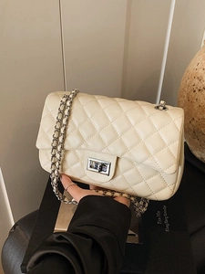 Elegant cream quilted flap bag with silver chain strap and metal turn-lock closure