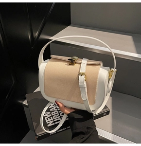 Detail of the chic contrast stitching and metallic gold buckle on this stylish pillow bag