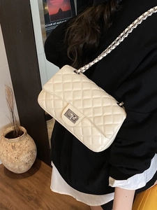 Chic quilted beige crossbody bag with silver chain strap and metal turn-lock closure