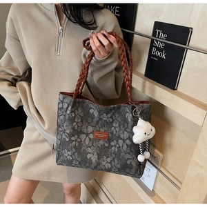 Floral tote bag detail with woven handles, brown leather patch, and fluffy cloud charm
